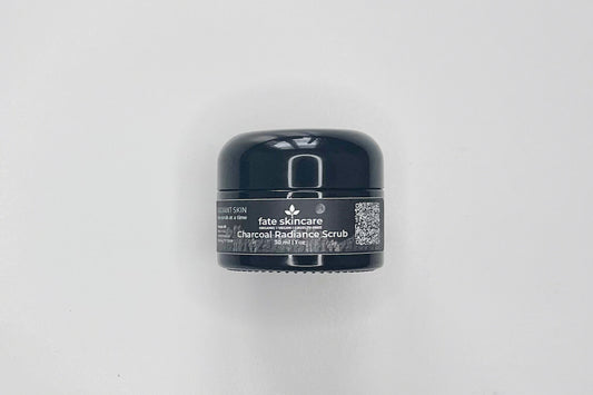 An image of Fate Skincare's Charcoal Radiance Scrub, in a black glass cosmetic container, with a black label, with wite writing and the iconic Fate Skincare logo.