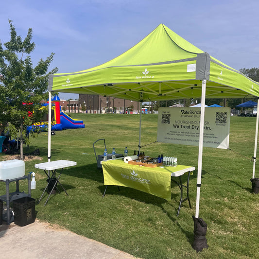 Lime green Fate Skincare tent at Crowley Market, with products on display and matching tablecloth.