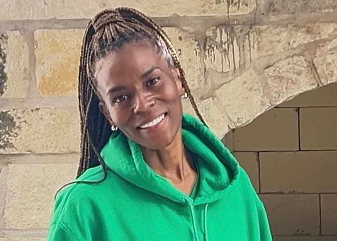 Promise Harris, President of Expansion at Fate Skincare, wearing a green hoodie.