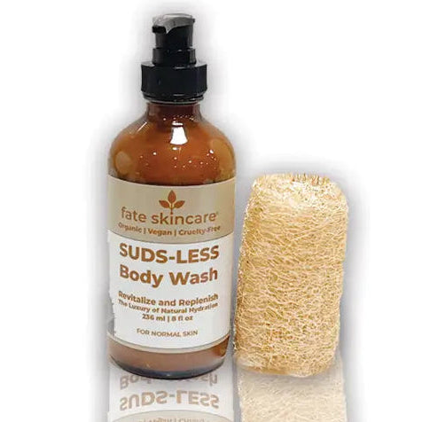Suds-Less Body Wash by Fate Skincare in an amber pump bottle with natural loofah, crafted as a gentle, herbal-based body cleanser that revitalizes and replenishes skin.