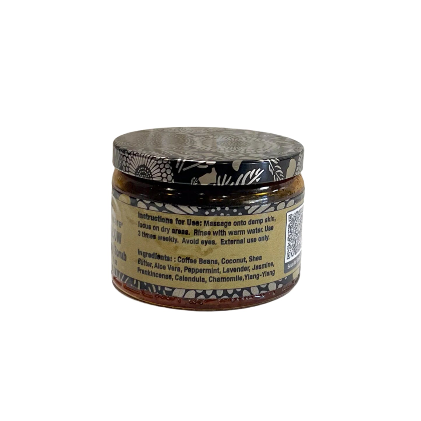 A close-up of the back label of the "Java Glow Coffee Body Scrub" jar, listing ingredients such as coffee beans, coconut, shea butter, aloe vera, peppermint, lavender, jasmine, frankincense, calendula, chamomile, and ylang-ylang. A QR code for additional details is also present.
