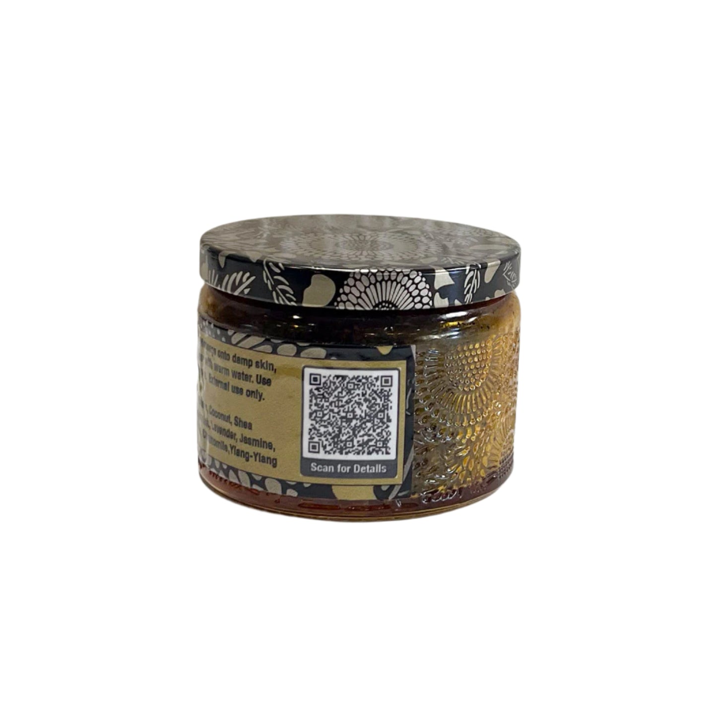 A close-up of the back label of the "Java Glow Coffee Body Scrub" jar, listing ingredients such as coffee beans, coconut, shea butter, aloe vera, peppermint, lavender, jasmine, frankincense, calendula, chamomile, and ylang-ylang. A QR code for additional details is also present.