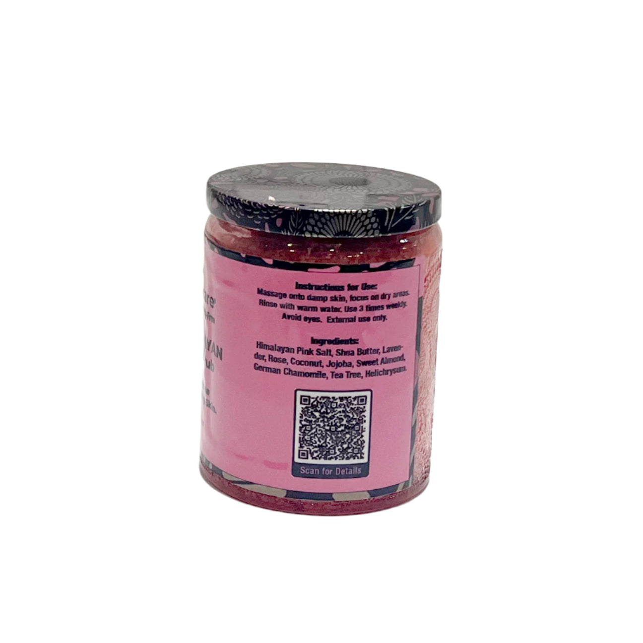 A glass jar with a black floral-patterned lid containing a pink Himalayan salt scrub. The back label includes usage instructions and a list of ingredients such as Himalayan pink salt, shea butter, lavender, rose, coconut, jojoba, and other botanical extracts. A QR code is at the bottom of the label.
