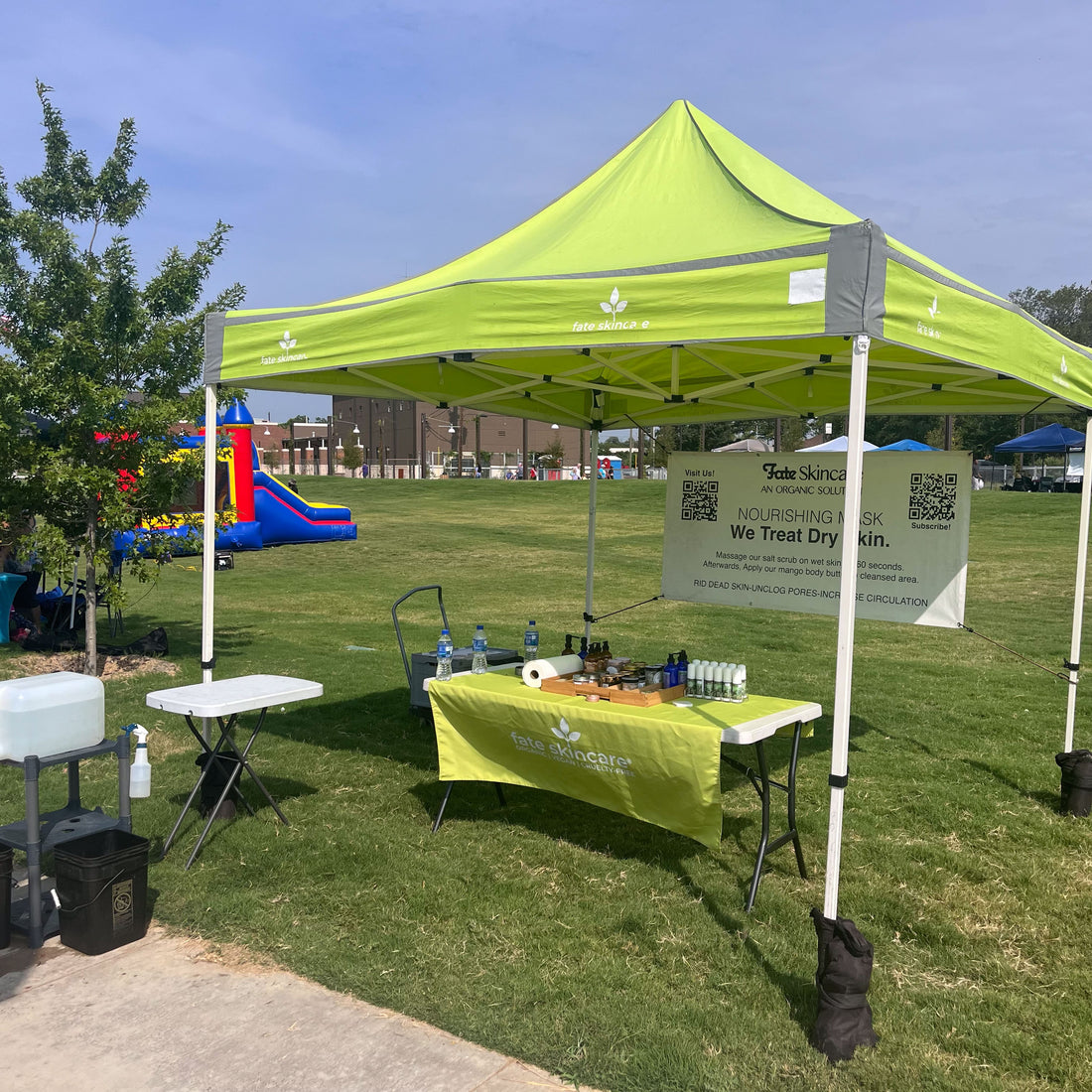Lime green Fate Skincare tent at Crowley Market, with products on display and matching tablecloth.