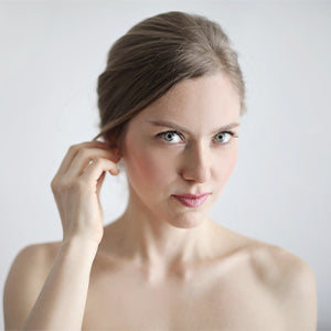 Woman smiling confidently, showcasing her radiant complexion achieved with Fate Skincare's natural and organic skincare products