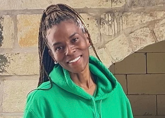 Promise Harris, President of Expansion at Fate Skincare, wearing a green hoodie.
