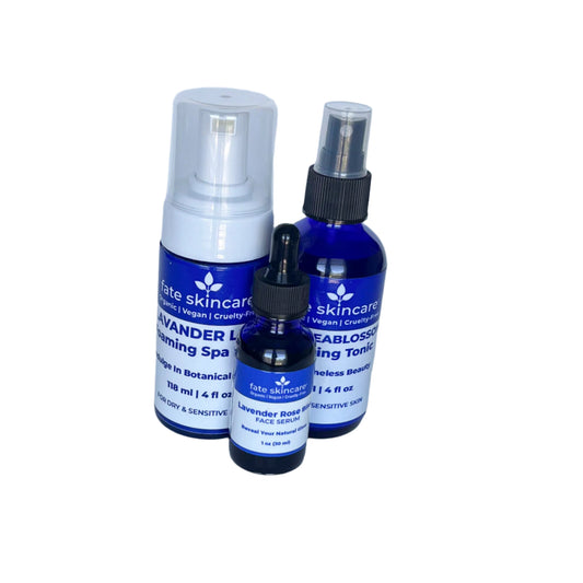 Fate Skincare's 3-piece skincare collection featuring a blue glass bottle of Lavender Rose Bliss Face Serum with a dropper, a 4 oz Lavender Luxe Foaming Spa Cleanser, and a 4 oz Seablossom Toning Tonic in matching cobalt blue bottles against a light background.